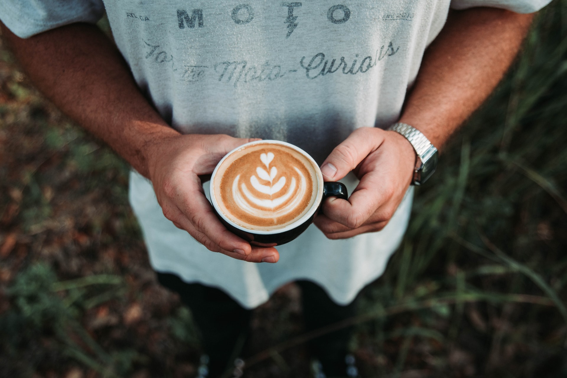 Man standing outside with a cup of coffee